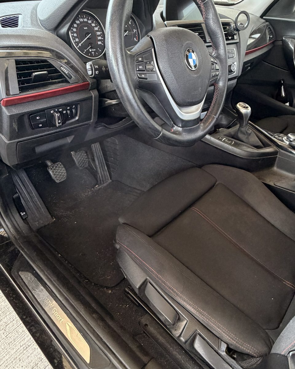 BMW-Fahrerseite vor der Aufbereitung: verschmutzter Fußraum und staubiger Sitz